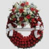 Corona funeraria con aro de claveles rojos y cabezal superior con flores blancas y rojas